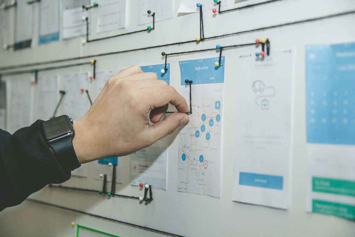 Hand arranging printed wireframes on a wall